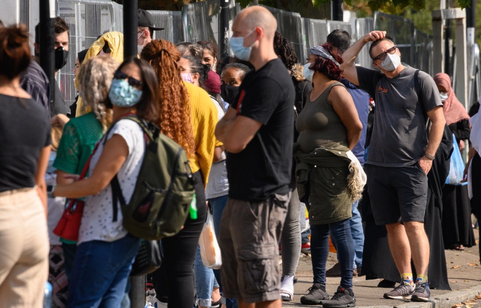 Queues stretch along the pavement at a walk-in Covid-19 testing centre in London