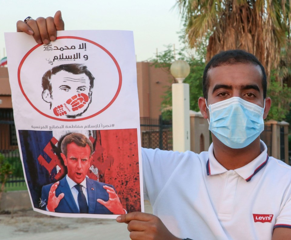 Kuwaitis lift a placard expressing anger at French President Emmanuel Macron