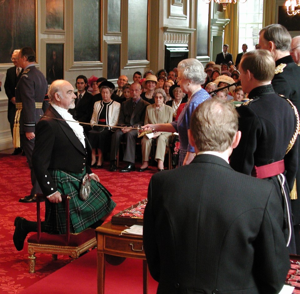 Kneeling as he was knighted by the Queen in 2000