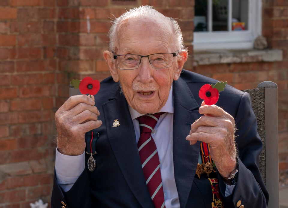 Captain Tom Moore holds two poppies showing his support for the British Legion