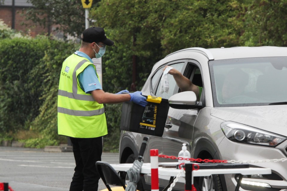 A worker carries out a coronavirus swab test at drive-in centre in Nottingham