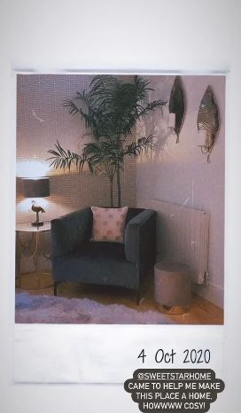 A snug grey arm chair is positioned by a flamingo lamp