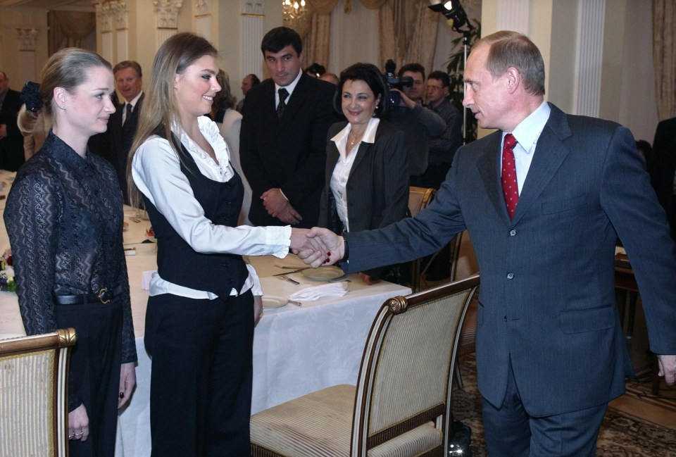 Vladmir Putin shakes hands with Alina while meeting the Russian Olympic team in 2004