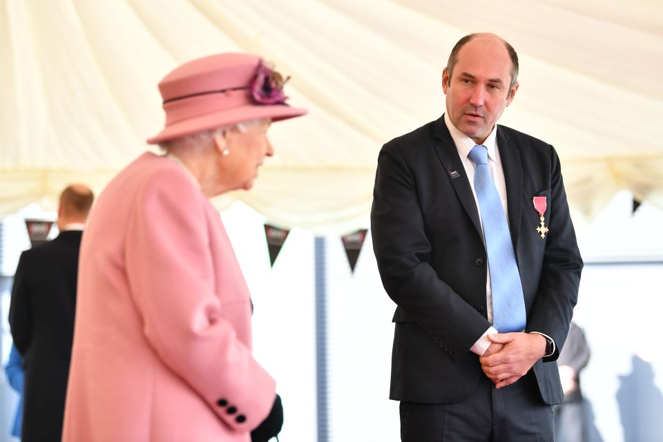 The Queen speaks with Professor Tim Atkins, who was honoured for his work on the 2018 Novichok incident and has been involved in the fight against Covid-19