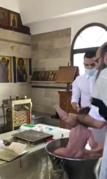 Footage shows the priest holding onto the baby and forcefully dunking it into the baptismal font in Limassol, Cyprus, on Saturday