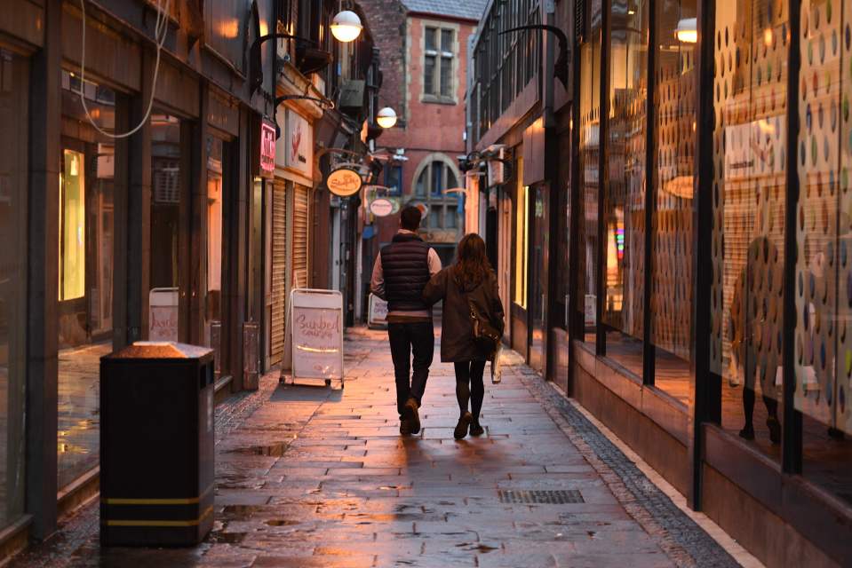 A couple walk past shuttered shops in Sheffield, which is in tier three