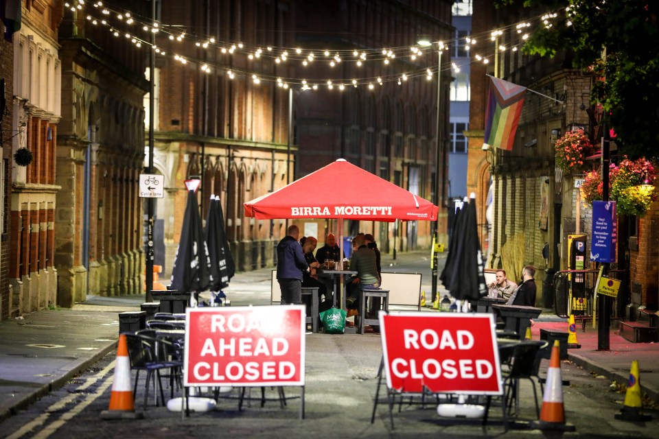 Drinkers in Manchester underneath some festive lights