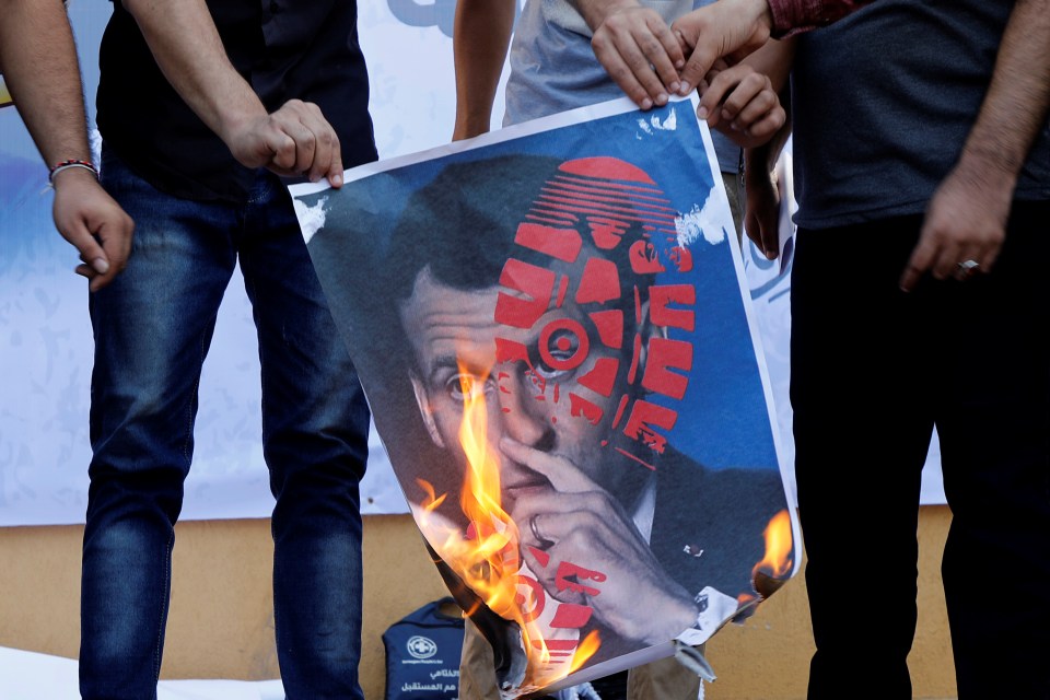 A picture of Macron is burned outside the French Cultural Center headquarters in Gaza city