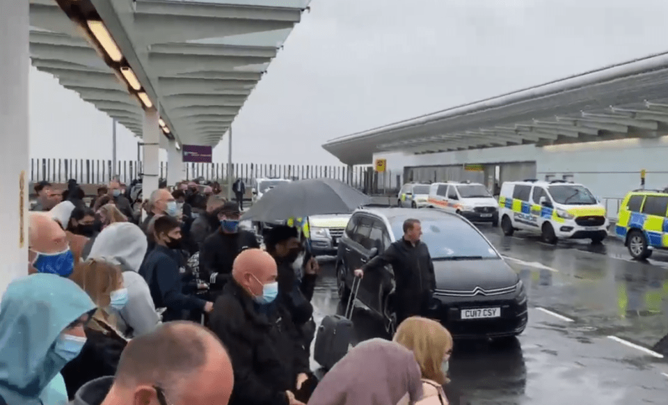 Passengers can be seen huddling away from the rain