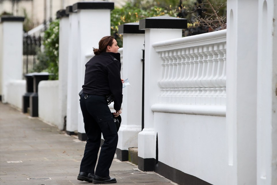 A police officer puts on a face mask to enter Rita's home