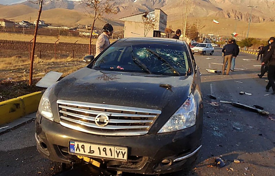 Pictures from the scene show a black car peppered with bullets and blood-soaked tarmac