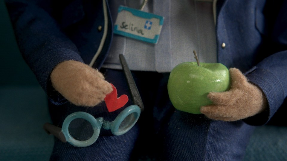 The kind-hearted nurse give her apple sticker to the little girl