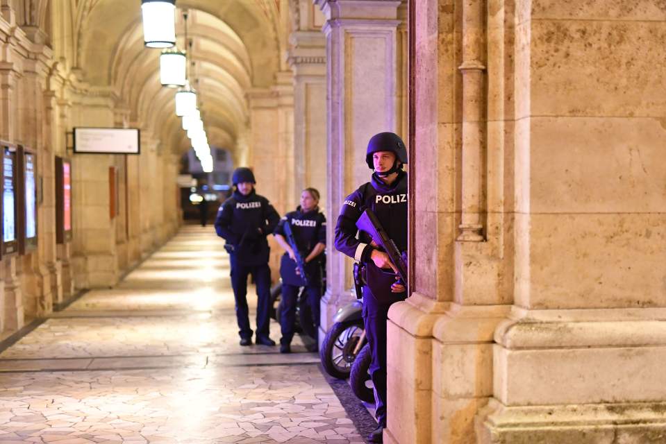 Armed police stand guard close to the scene