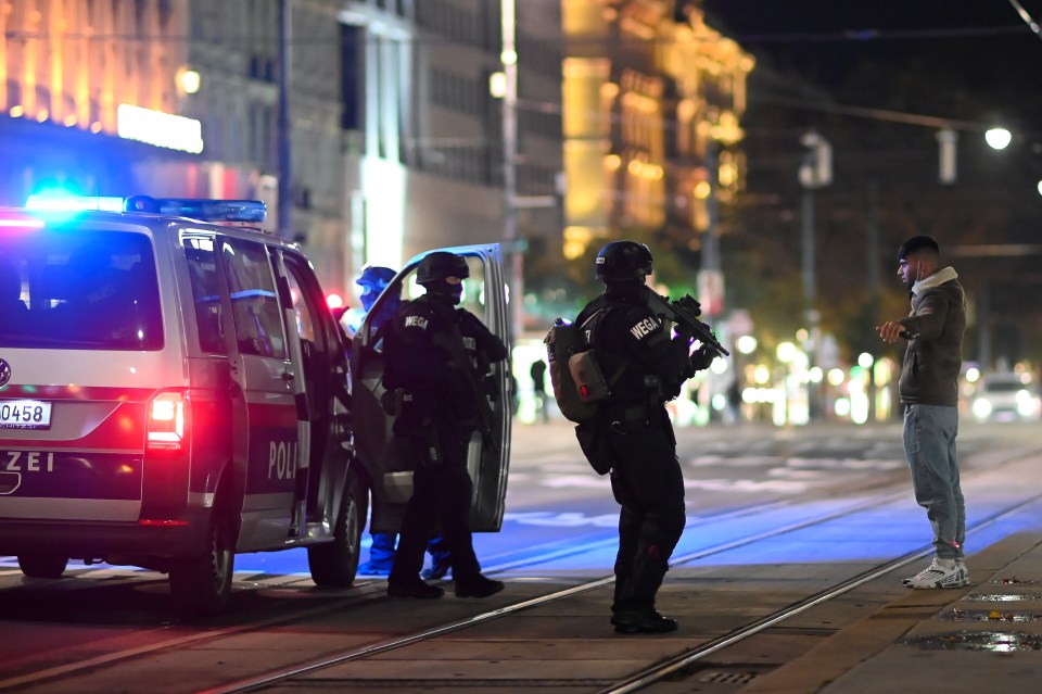 Armed police stop a man near the scene