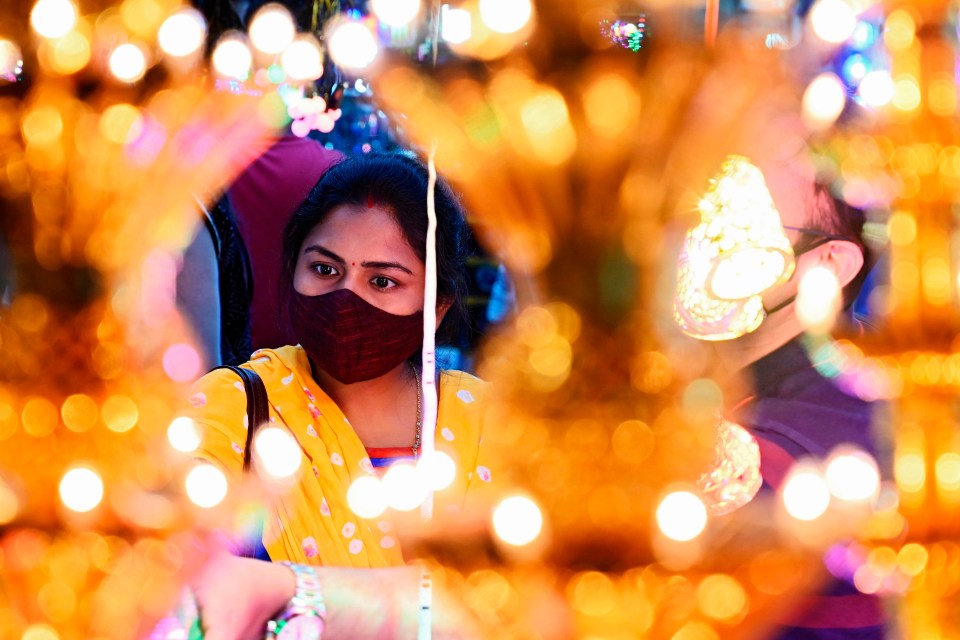 A woman shops for decorative items at a roadside market ahead of the Hindu festival Diwali, the festival of lights, in Kolkata