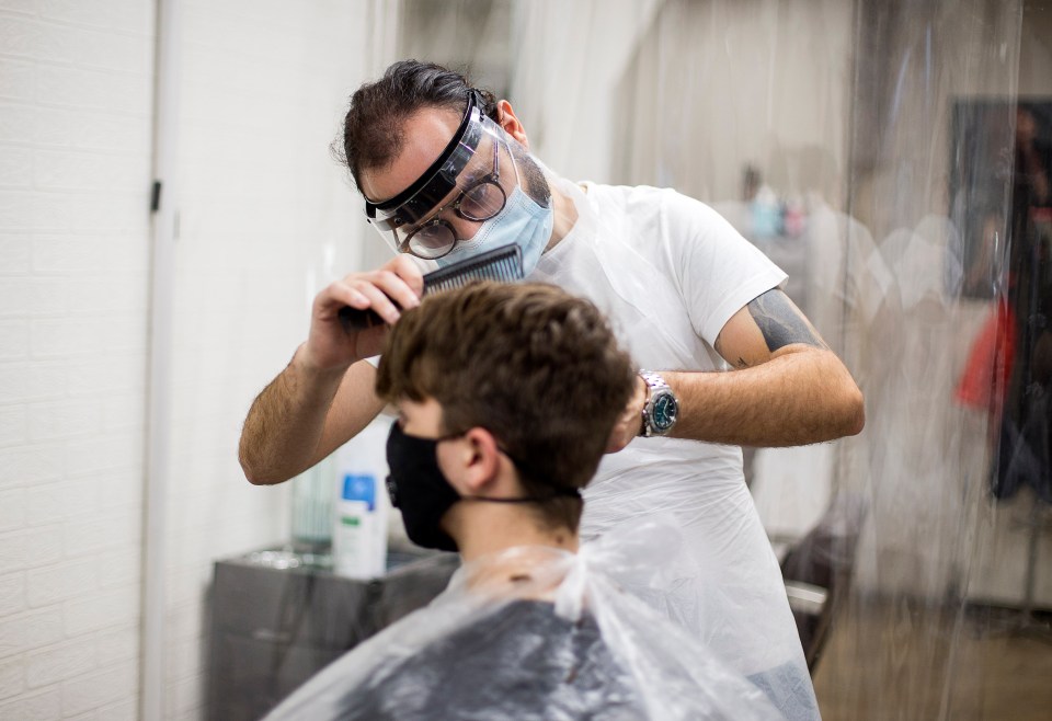 Barber Stavros Andreou gets to work at his shop in Pontypridd, South Wales as the firebreak ends today