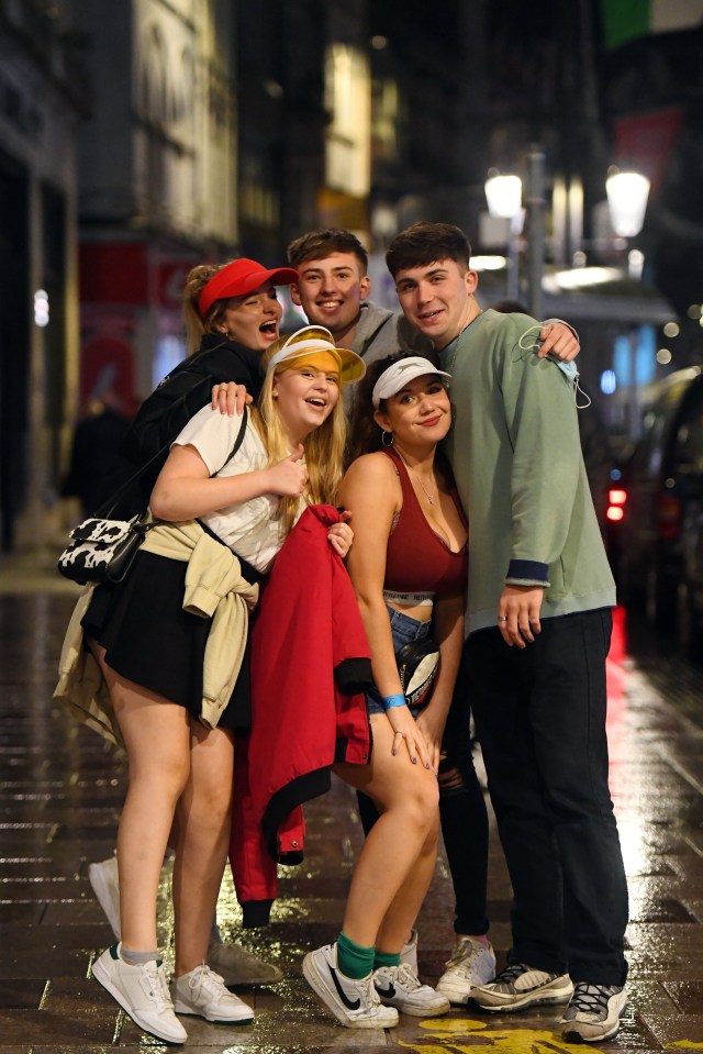 Revellers celebrate the end of Wales’ 17-day lockdown by flocking to bars in the rain