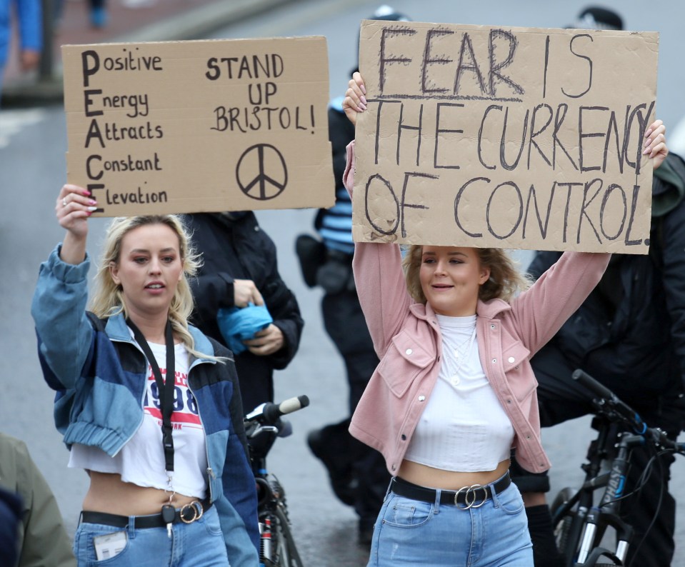 Marchers wave signs warning "fear is the currency of control"