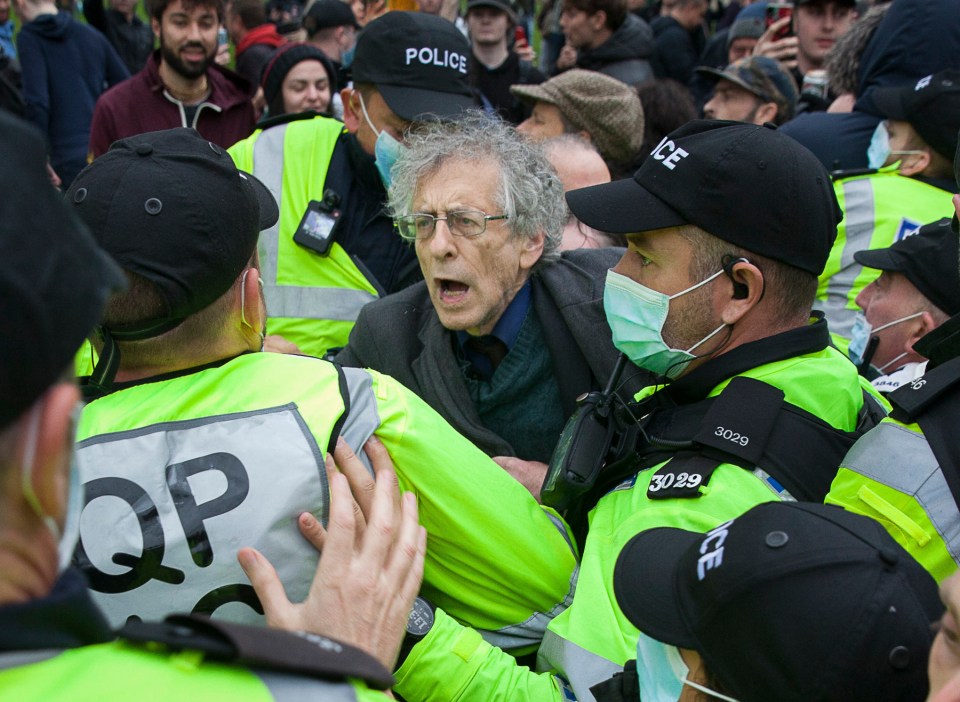 Piers Corbyn is led away by police amid a throng of protesters in Bristol