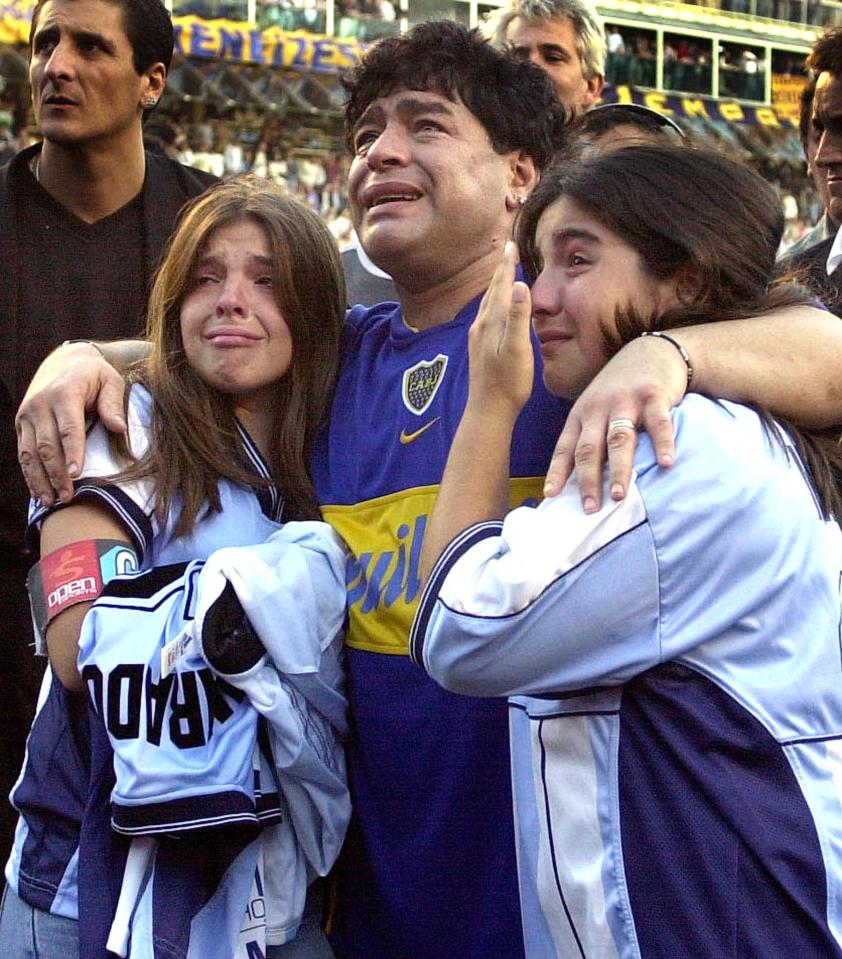 Maradona hugs his daughters Dalma Nerea (l) and Gianinna Dinora (r) during a tribute match held in his honour at Boca Juniors Stadium in 2001