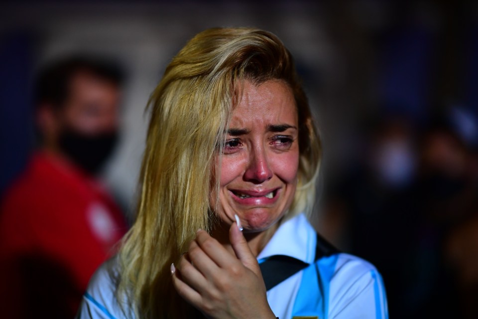 A fan of  Maradona cries as she gathers with other fans to pay homage on the day of his death 