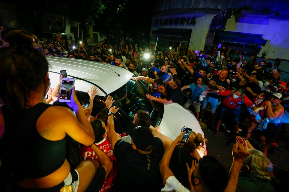 Fans surround the hearse carrying the coffin of Diego Maradona as it arrives to a funeral parlor in Buenos Aires