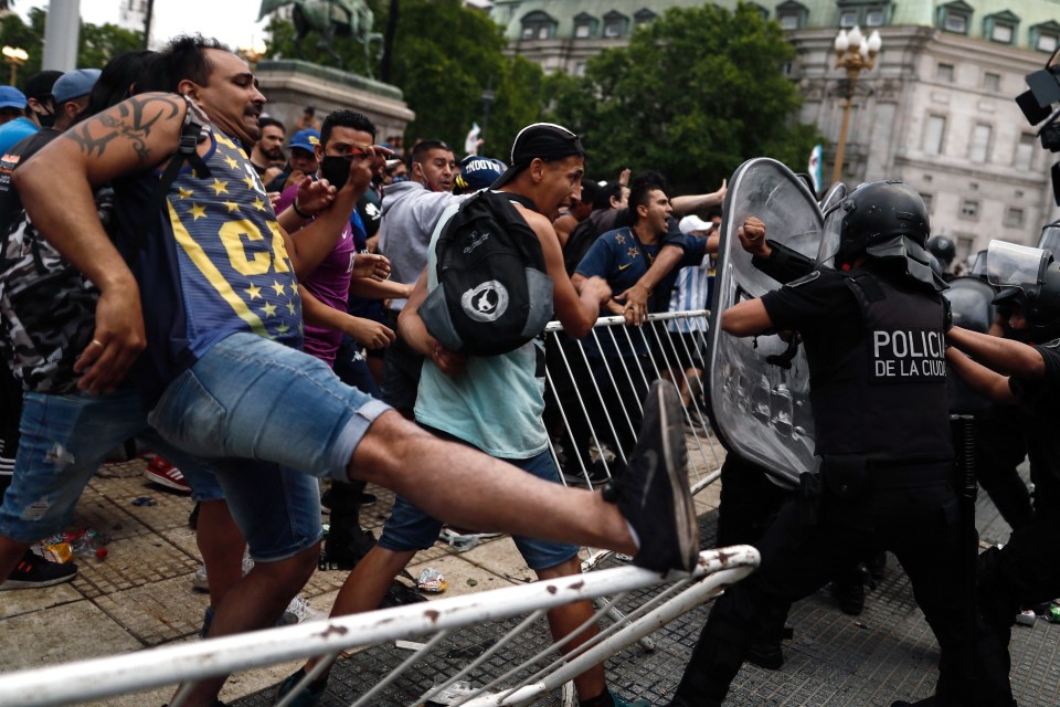 Fans kick down barricades as they scramble to see Maradona’s coffin