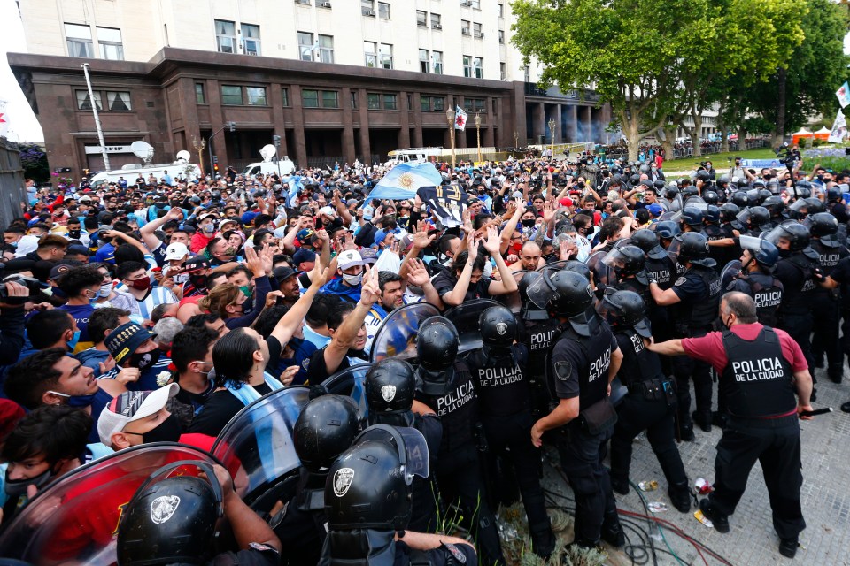 Police try to keep order against the surging throng of Maradona fans