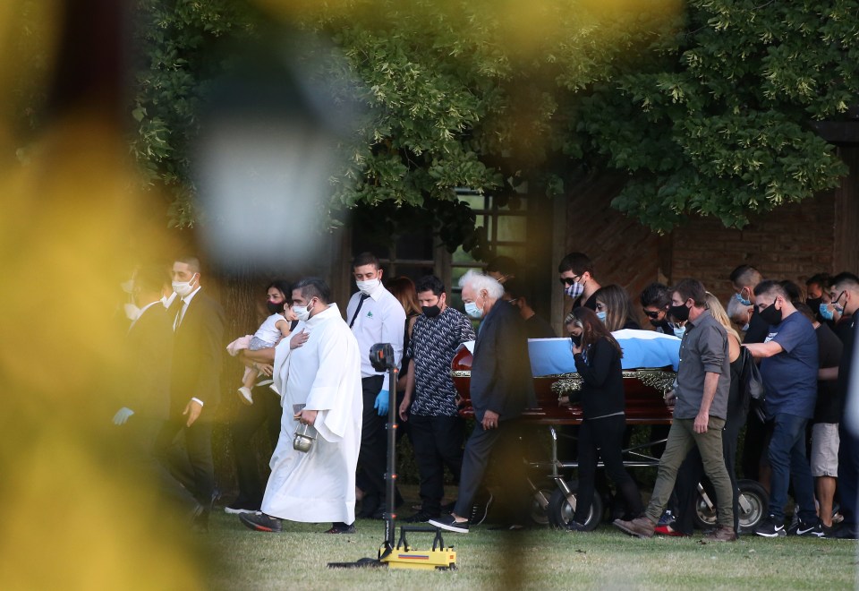 Friends and family carry the casket of the football legend