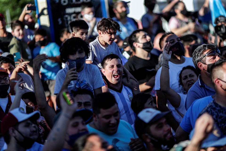 People mourn Maradona’s death on the street near the cemetery where he is being buried