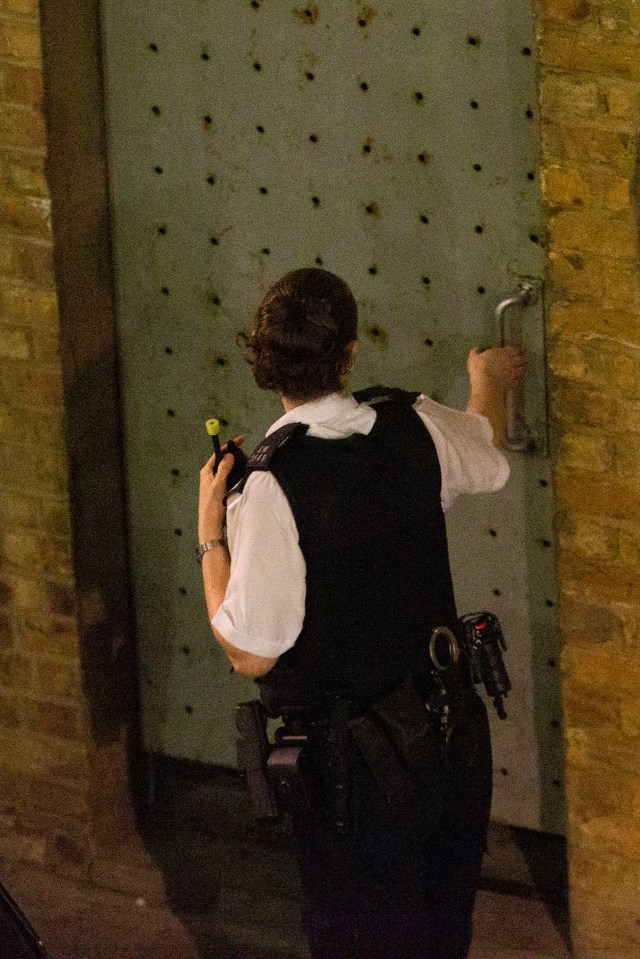 Officers were seen peering through the windows and trying to open a heavy-duty security door