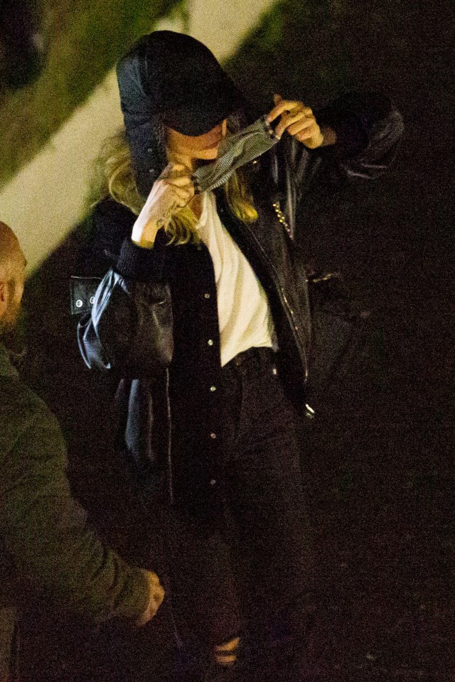 Cara Delevingne puts on a mask outside the venue