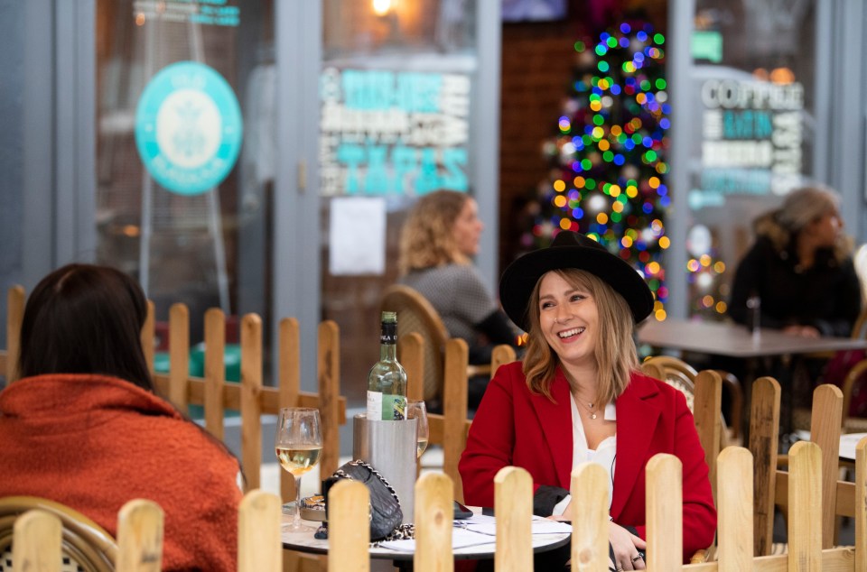 Two women share a bottle of wine at a bar on St. Mary Street in the Welsh capital