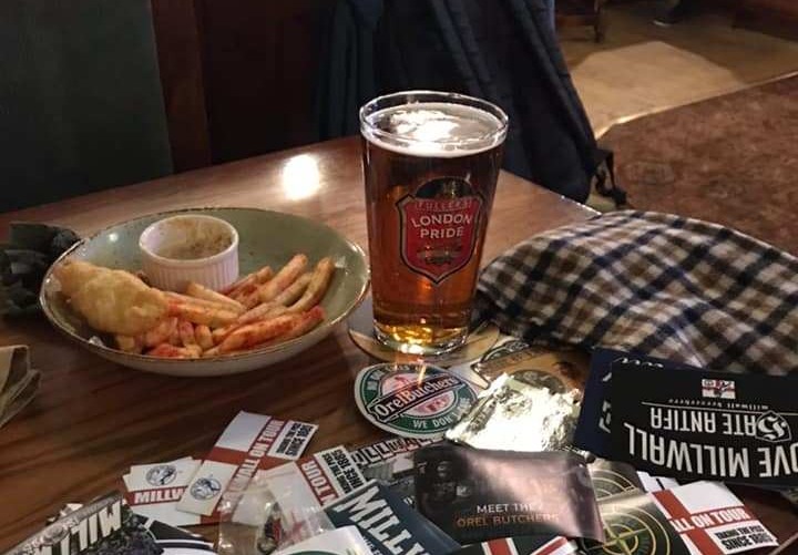 Millwall fans enjoy a pint of London Pride and a plate of fish and chips at Churchill's Pub