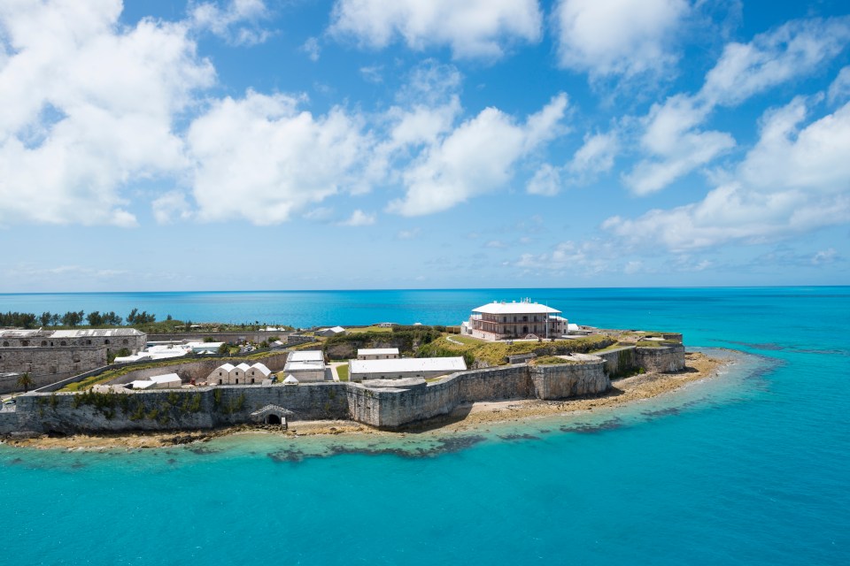 A cruise ship departing Bermuda as it sails past the Royal Naval Dockyard