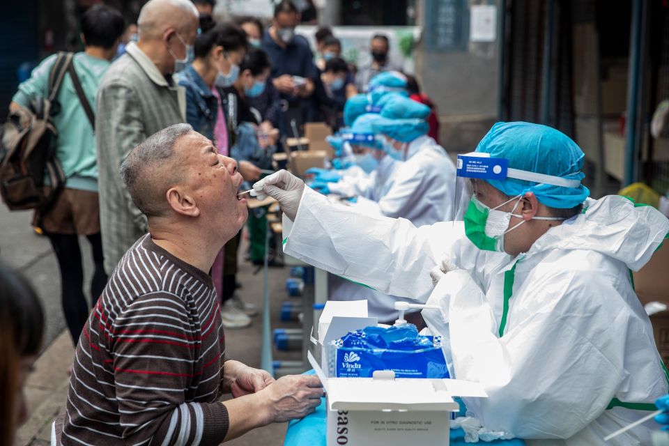 Medical workers take swab samples from residents in Wuhan