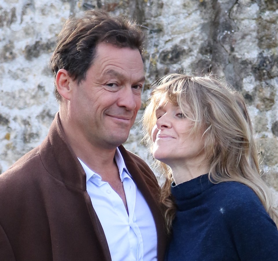 Dominic West’s smug grin in this snap with his humiliated wife Catherine clinched his OBE