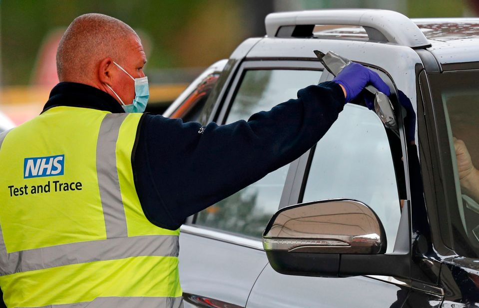 A driver receives a coronavirus self-test kit from an NHS Test and Trace worker