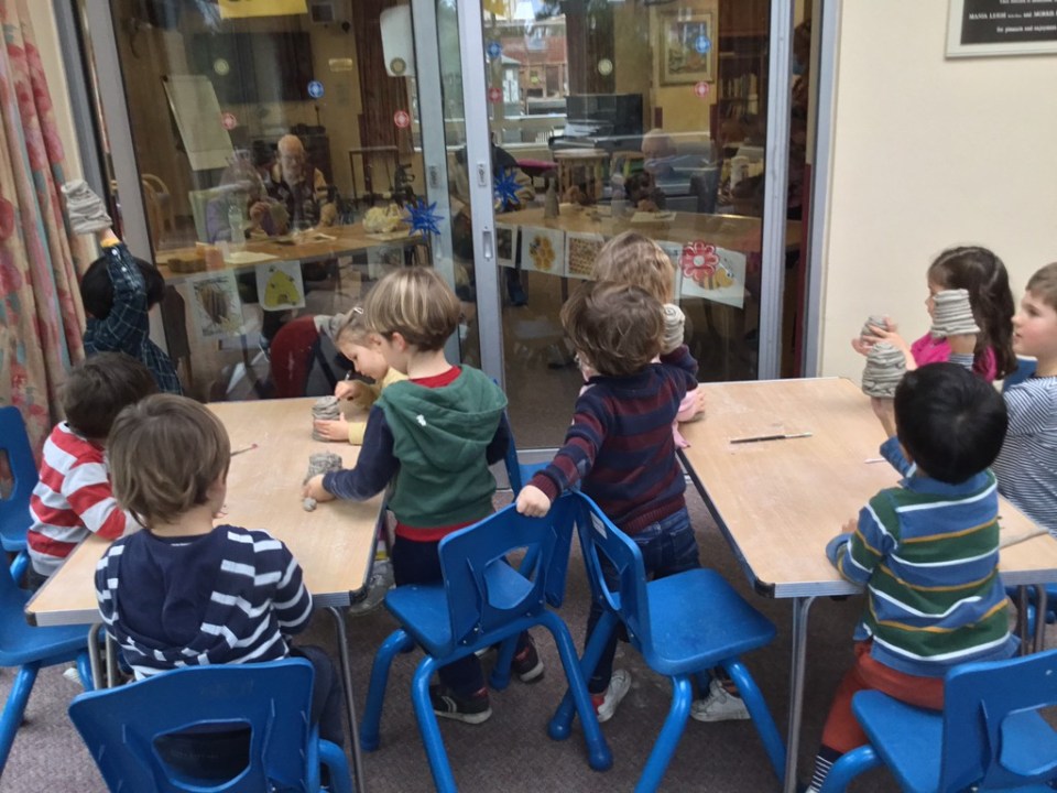 Children making beehives, watched by care home residents, at Apples and Honey Nightingale