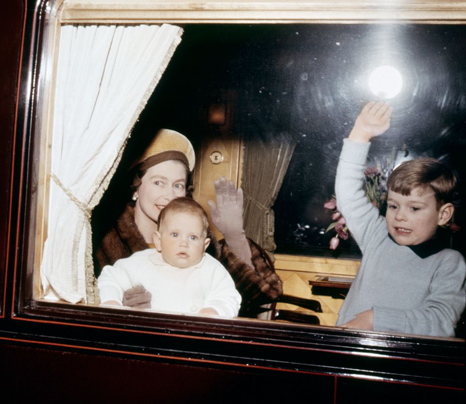 Queen Elizabeth II with Prince Edward (on her lap) and Prince Andrew on the train in 1964