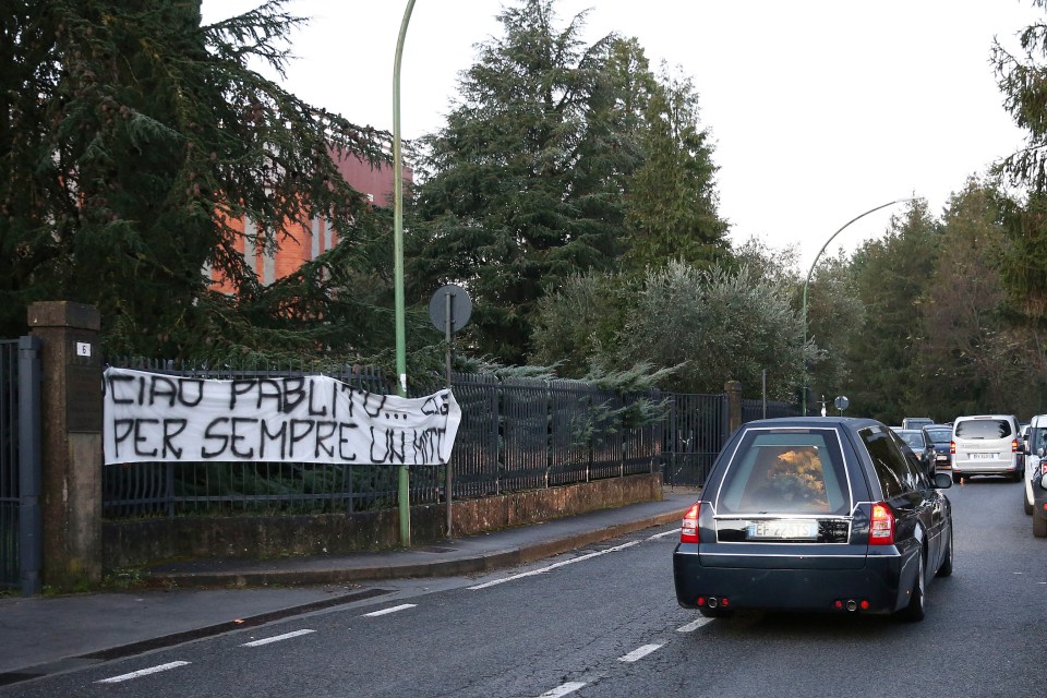 Fans put up banners in tribute to Rossi as his body was taken to Siena