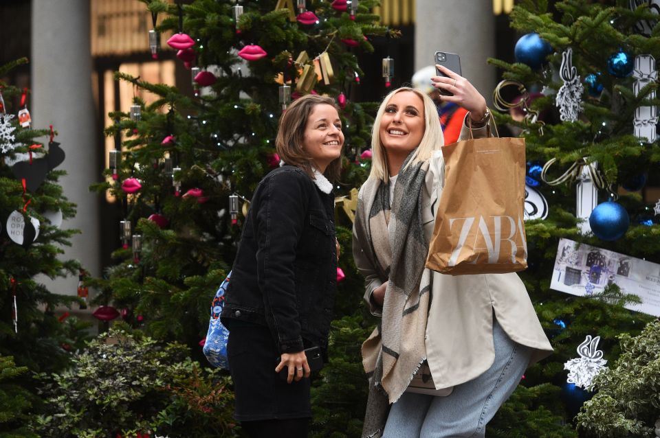 Two friends smile and pose for a photograph in London before the lockdown was announced