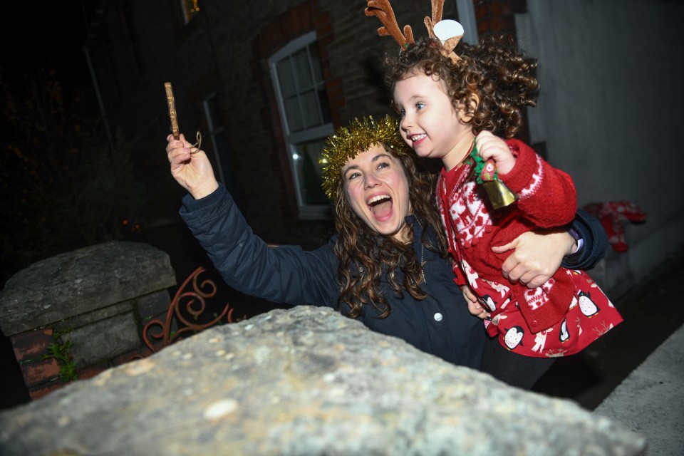 Lillian Joy, aged three and her mum, Bethan, ring a bell to spread festive cheer outside their home in Swansea, south Wales