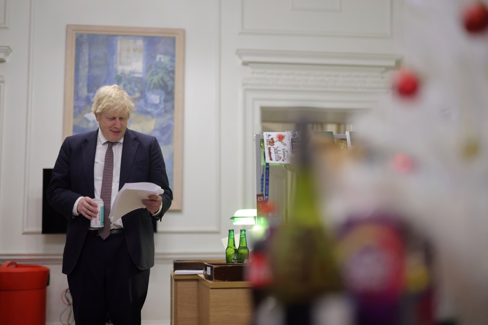 Boris Johnson reads an important document holding a can of Spinnaker IPA