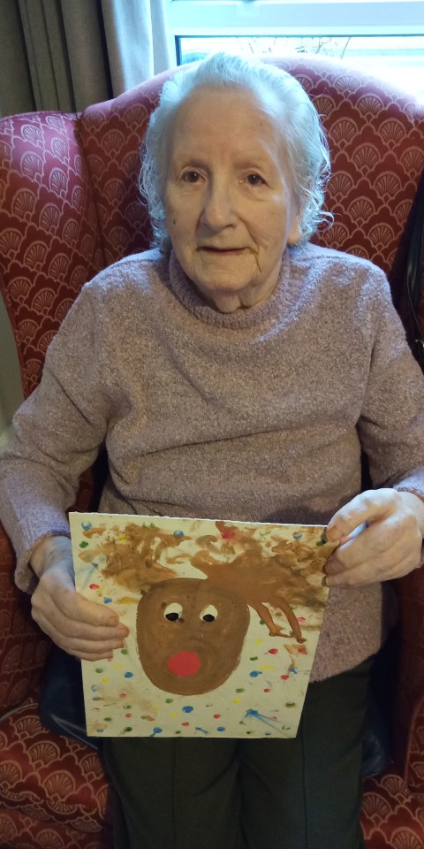 Betty holding the painting Wilfred made her