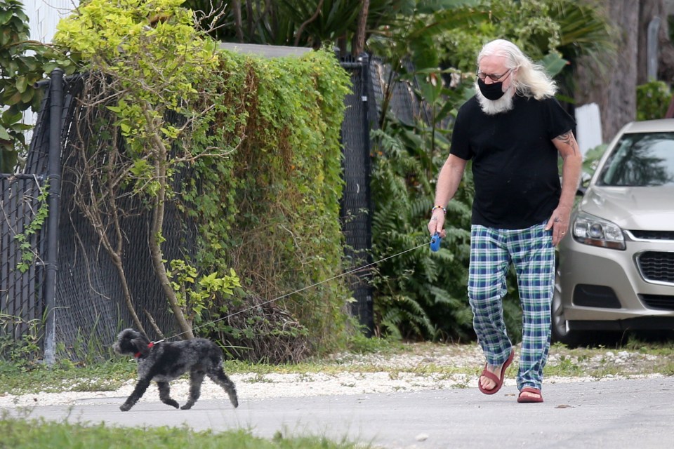 Billy wore a black T-shirt and sported a pair of red sandals