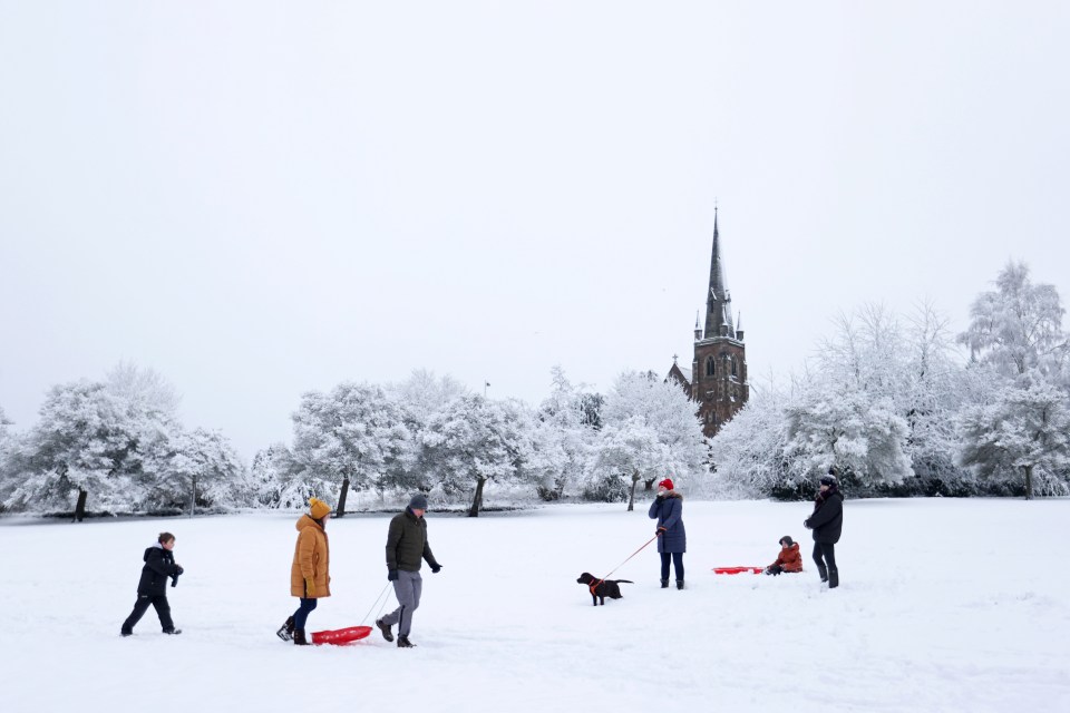 Families enjoy a morning play in the snow in Keele, Staffordshire