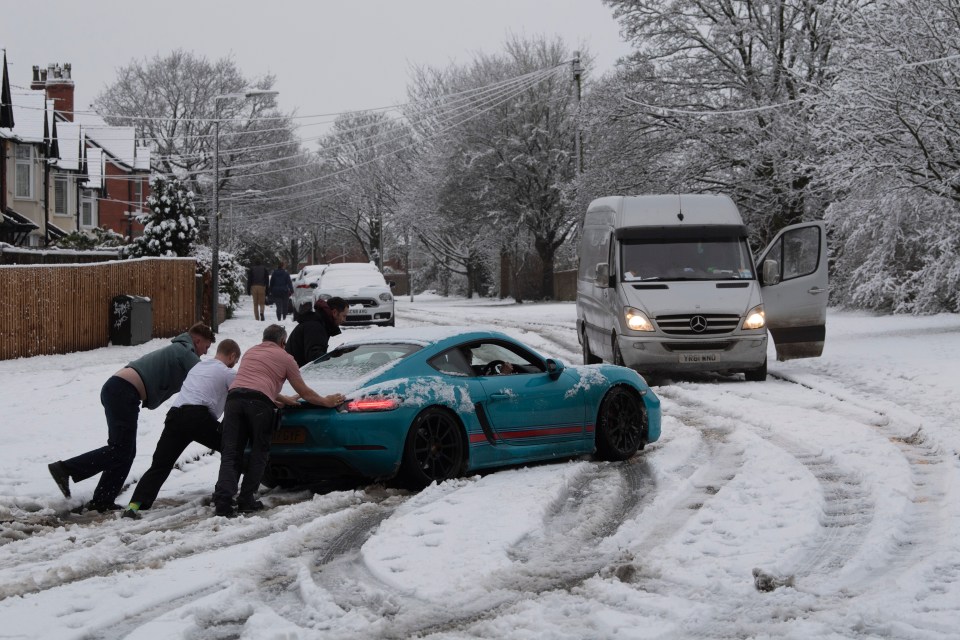 Kind-hearted neighbours push a Porsche through the snow in Cheshire 