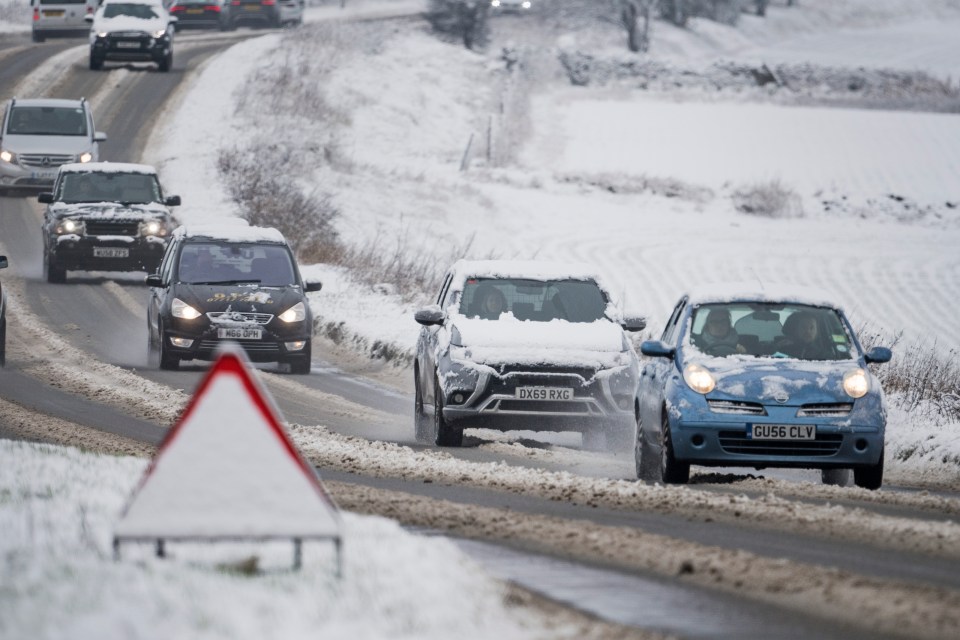 Traffic battles through heavy snow near the village of Burford in Oxfordshire