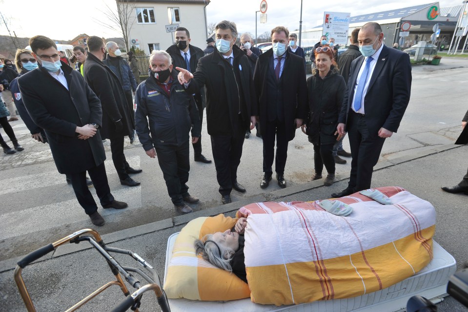 Croatian Prime Minister Andrej Plenković next to an elderly woman who was evacuated 